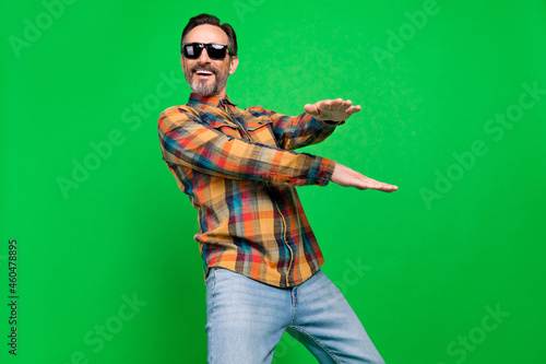 Portrait of attractive funky cheerful man dancing having fun clubbing free time isolated over bright green color background #460478895