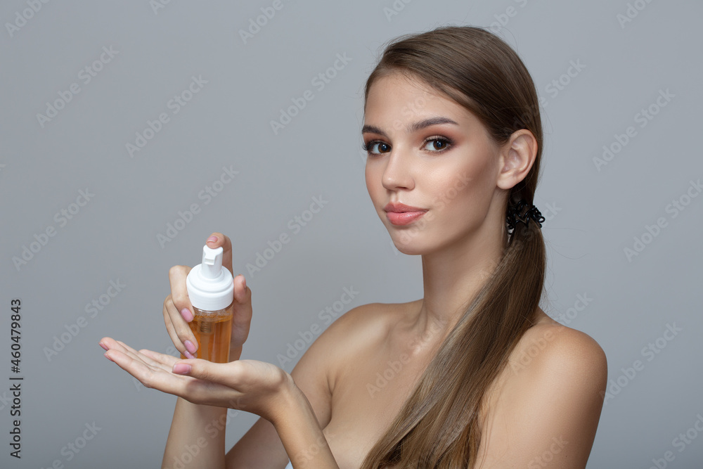 young woman with perfect skin carries out a wash. Gray background young woman with perfect skin carries out a wash. Gray background