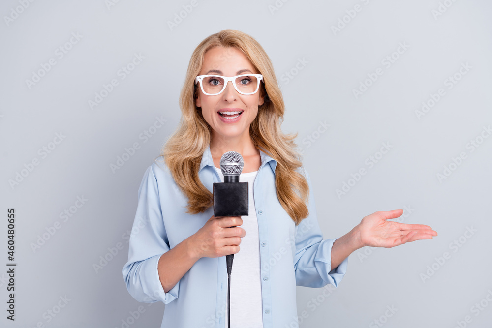 Photo of popular correspondent hold mic talk speak tell news wear specs blue shirt isolated grey color background Photo of popular correspondent hold mic talk speak tell news wear specs blue shirt isolated grey color background