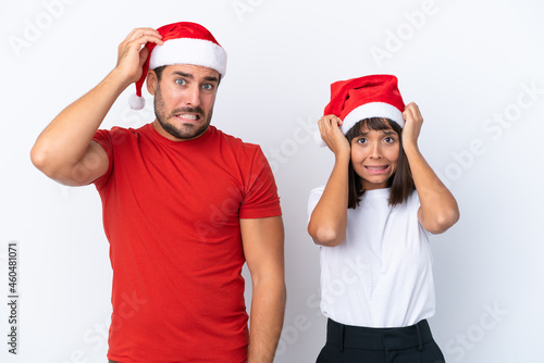 Young couple with christmas hat isolated on white background takes hands on head because has migraine