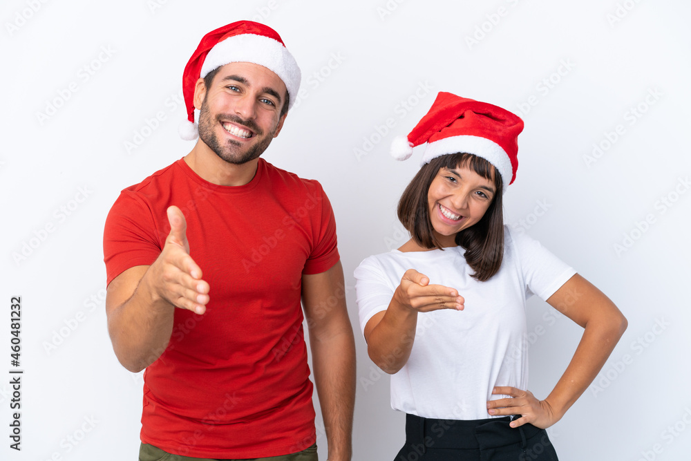 Young couple with christmas hat isolated on white background shaking hands for closing a good deal Young couple with christmas hat isolated on white background shaking hands for closing a good deal