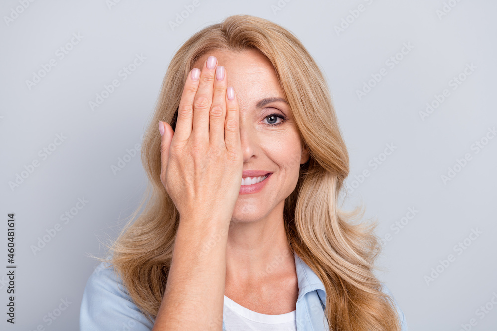 Portrait of young smiling good mood female cover close half face eyesight vision isolated on grey color background Portrait of young smiling good mood female cover close half face eyesight vision isolated on grey color background