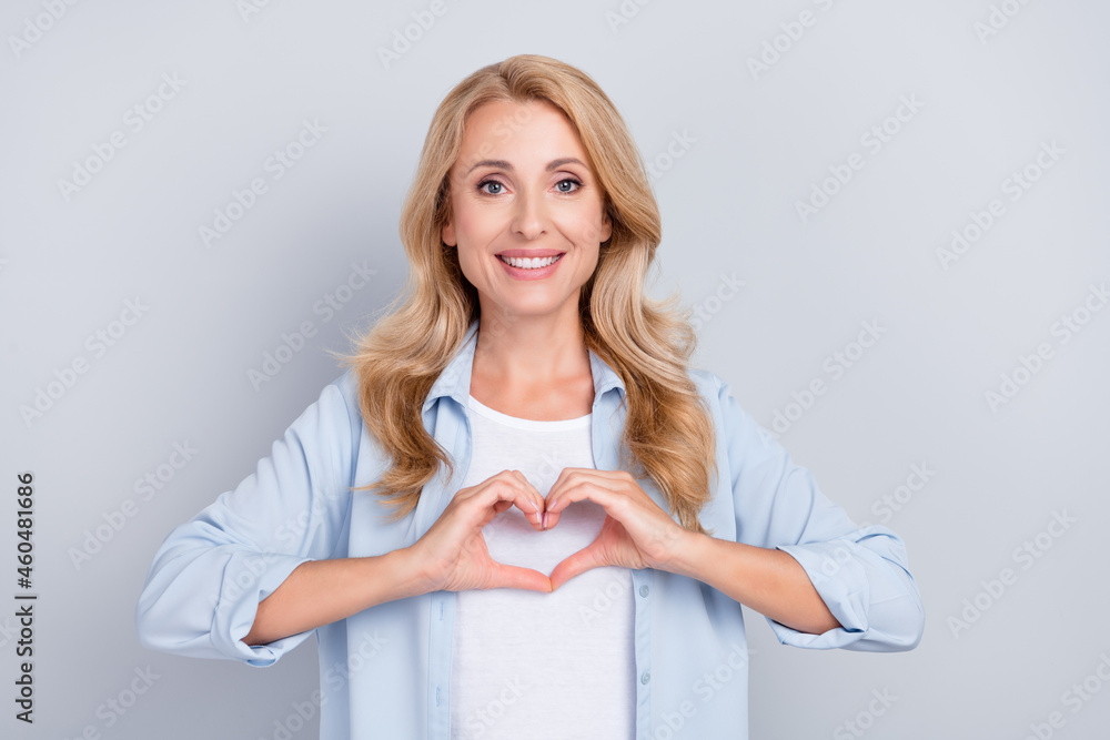 Photo of affectionate charming lady fingers showing heart symbol wear blue shirt isolated grey color background Photo of affectionate charming lady fingers showing heart symbol wear blue shirt isolated grey color background