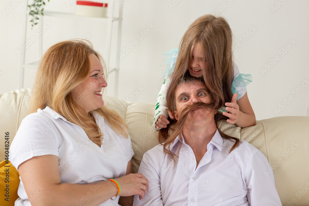 Family sitting on sofa in their living room. Daughter have injury hand but she is happy be together her family. Family sitting on sofa in their living room. Daughter have injury hand but she is happy be together her family.