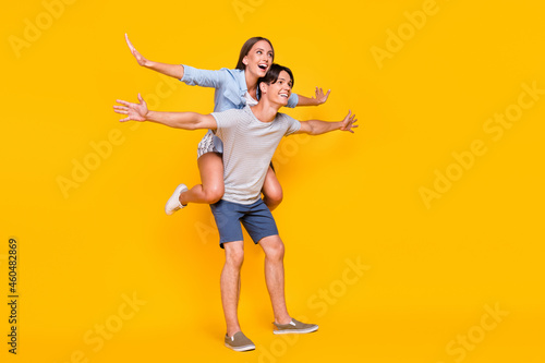 Fotografie Full length body size view of attractive cheerful carefree couple piggy backing