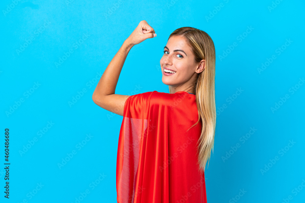 Blonde woman over isolated background in superhero costume and doing strong gesture Blonde woman over isolated background in superhero costume and doing strong gesture