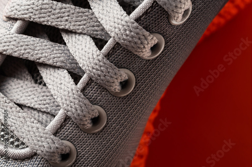 Wallpaper Mural Lacing of gray textile sneakers with orange sole close-up. New sport shoe laced up macro. Elastic laces of modern mesh fabric trainers for fitness, sport exercises and active lifestyle. Torontodigital.ca