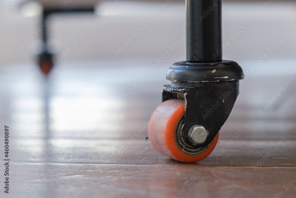 Obraz premium Close-up of heavy duty caster wheel on the floor. Mobile furniture on small wheels. Rack wheel for move equipment.