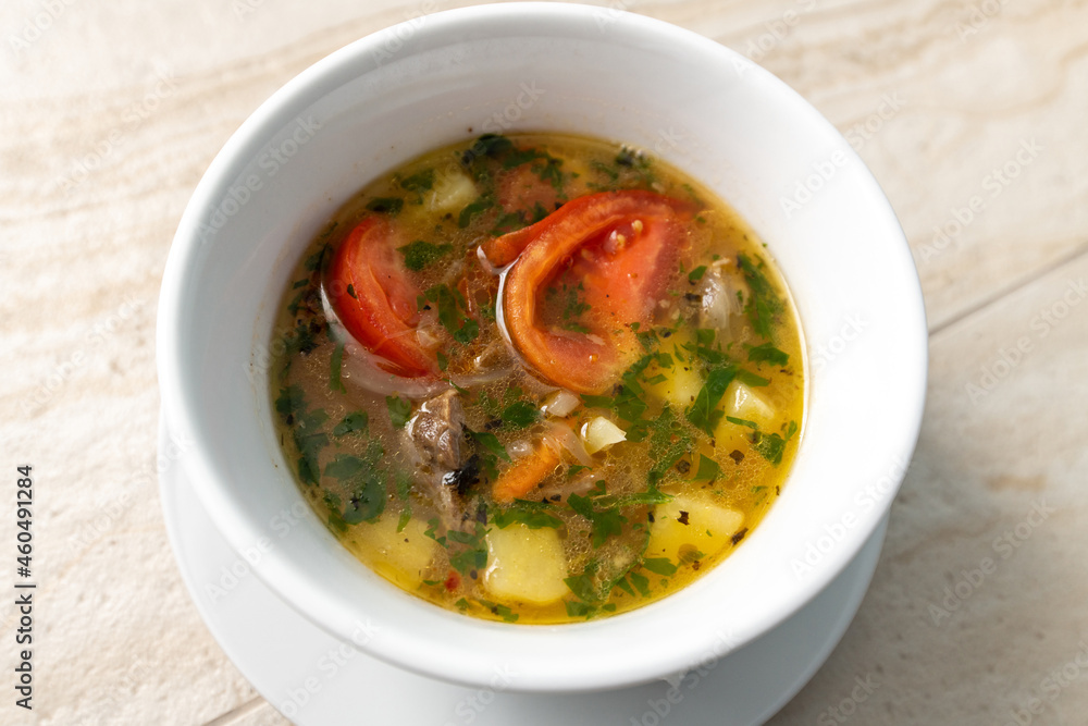 Hot meat soup with tomatoes and potatoes