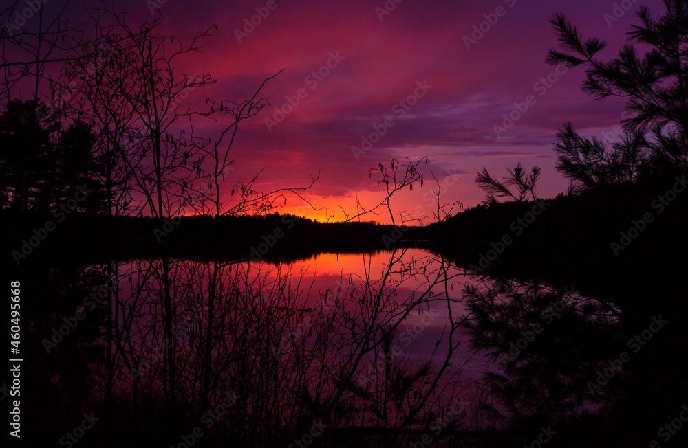 Deep red sunset over the lake with silhouette