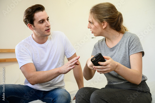 Young Caucasian woman feeling angry and quarrel with boyfriend after found hidden love affair evidence in smartphone. Love affair couple relation problem concept. photo