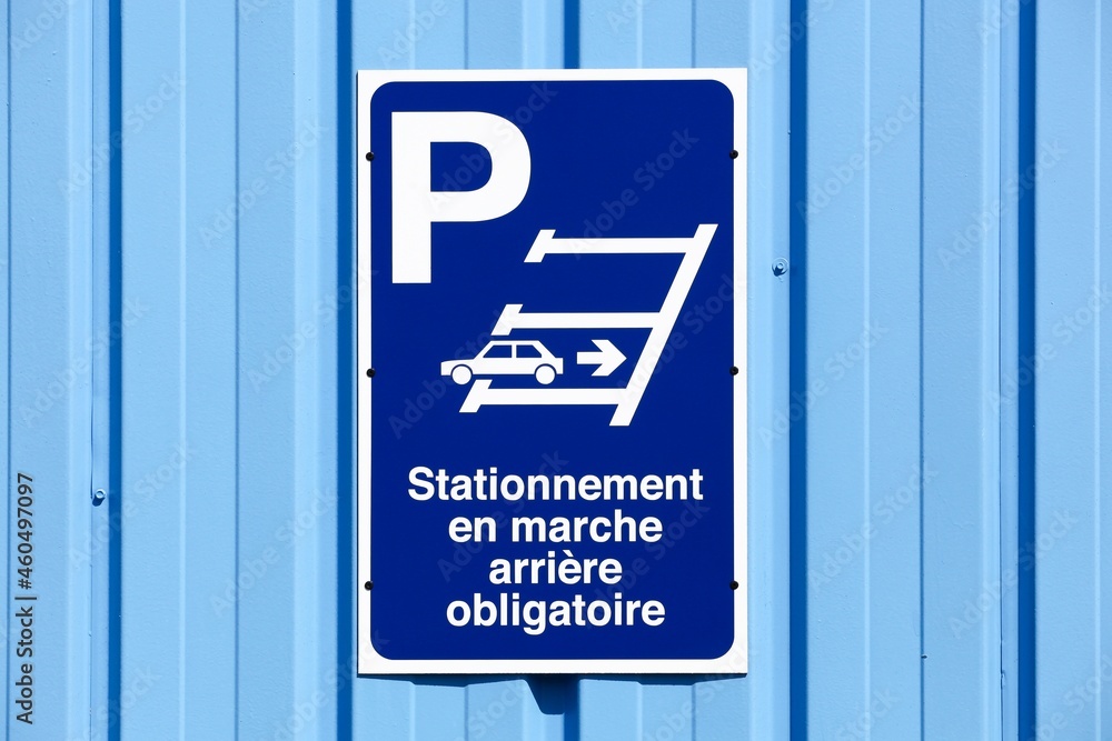 Fototapeta premium Reverse parking only sign on a wall called stationnement en marche arriere obligatoire in french language