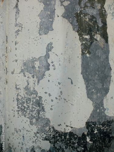古びて塗装がぼろぼろの白い金属壁