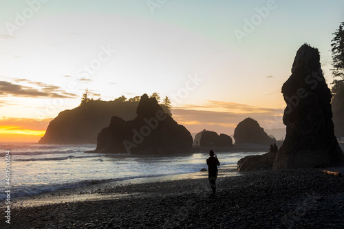 A lone person watching the dramatic sunset sky in Rialto Beach.