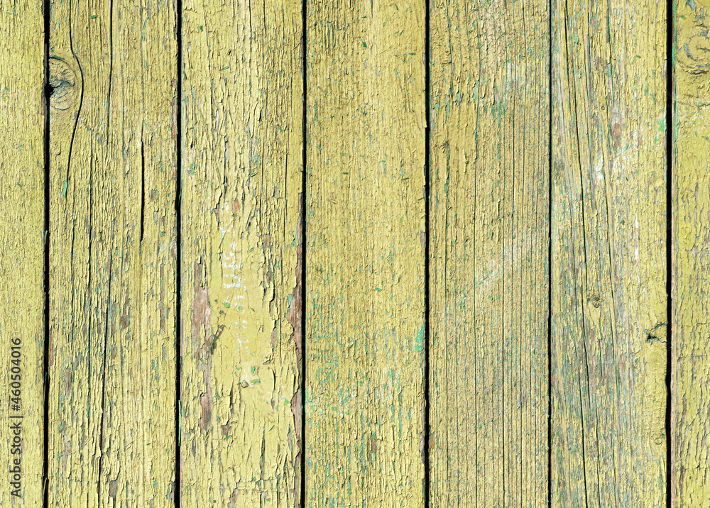Old yellow wooden wall with cracked paint, background texture