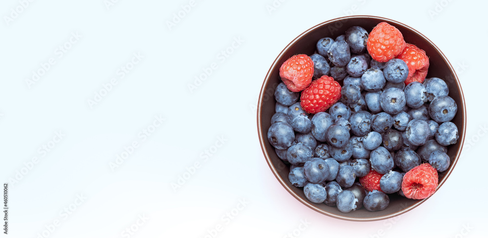 Blueberries mixed with raspberries in a cup, top view. Blueberries mixed with raspberries in a cup, top view.