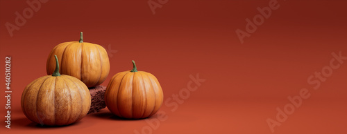 Three Pumpkins on a Deep Orange colored background. Fall themed Banner with copy-space.
