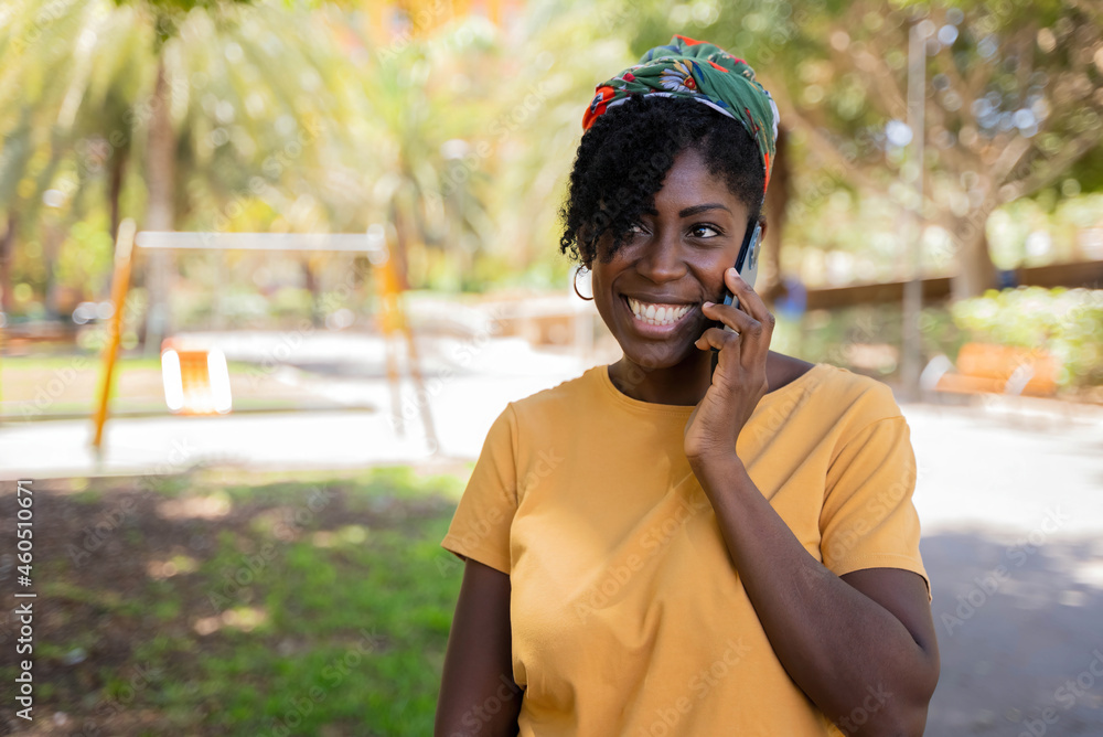 black woman smiling while talking on mobile phone on the street black woman smiling while talking on mobile phone on the street