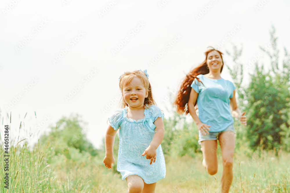 Fototapeta premium daughter runs towards her mother on the grass
