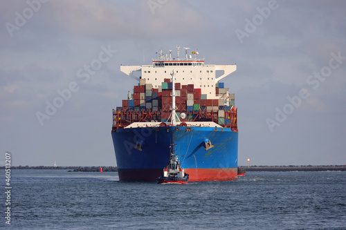 Blaues Containerschiff kommt im Hafen an