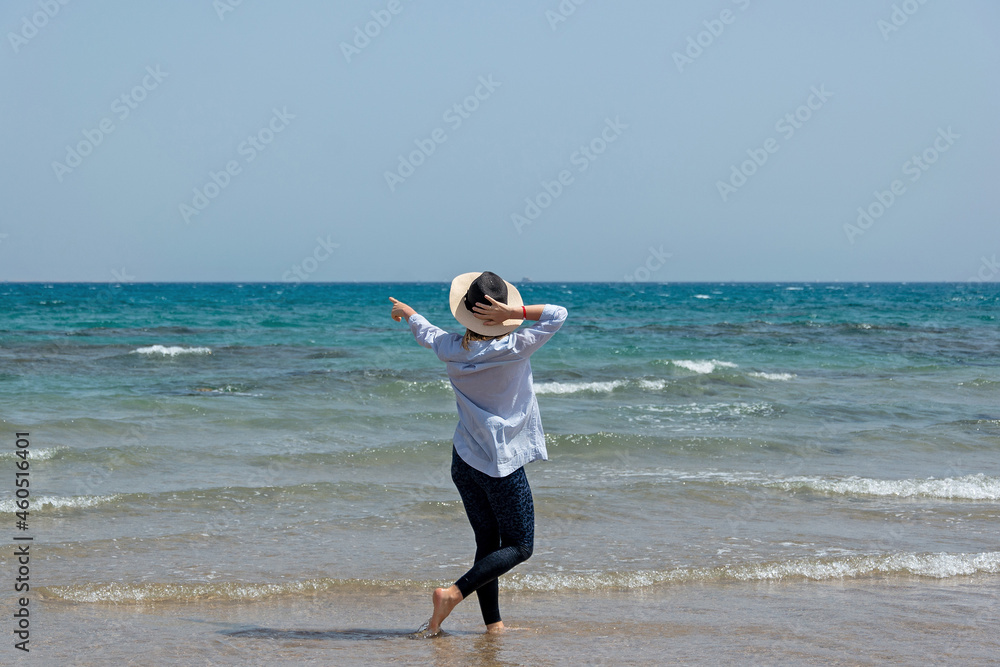 Cheerful tanned woman at beach enjoying nature-freedom. outdoor at tropical resort with her arms outstretched the wind. Beautiful young female enjoying day at ocean beach Cheerful tanned woman at beach enjoying nature-freedom. outdoor at tropical resort with her arms outstretched the wind. Beautiful young female enjoying day at ocean beach