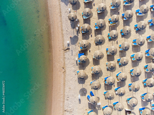 Top down view of a beach with tourists suntbeds and umbrellas with sand beach and clear blue water in egypt
