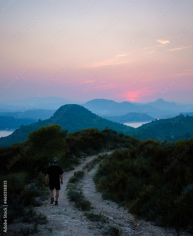 a sunset with many colors with a person on the way