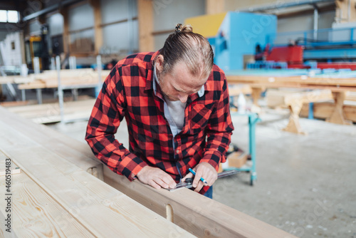Carpenter or joiner working with timber in a factory workshop