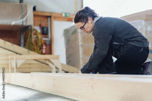 Female worker in a woodworking factory working on a frame