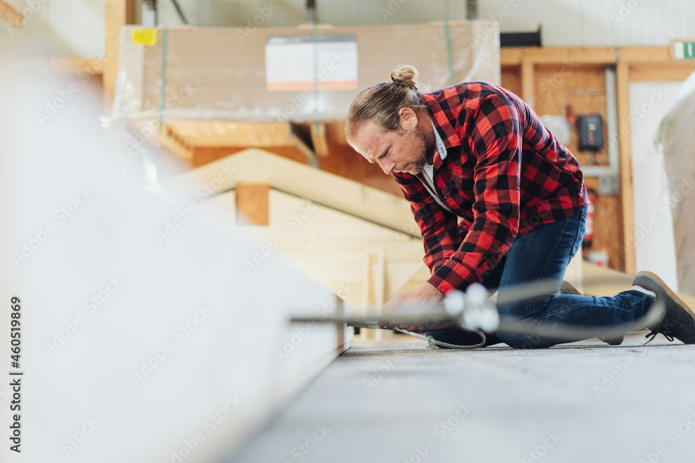 Carpenter working kneeling down on a timber frame Carpenter working kneeling down on a timber frame
