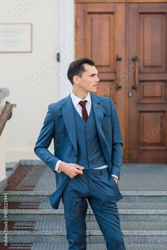 Portrait of an attractive young businessman in urban background wearing suit and a tie.