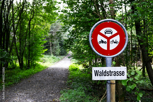 Red no driving sign near a forest road with German sign "Waldstrasse".