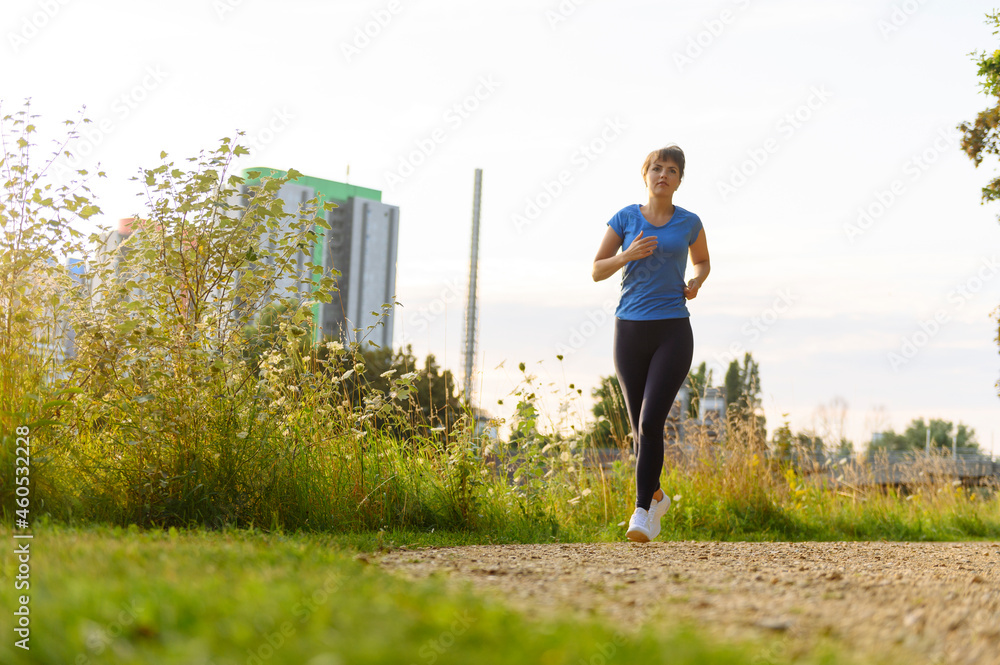 woman jogging in park at sunset