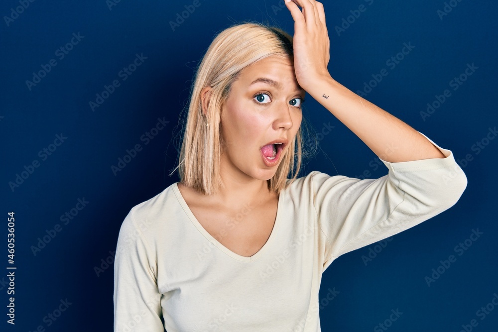 Beautiful blonde woman wearing casual sweater surprised with hand on head for mistake, remember error. forgot, bad memory concept. Beautiful blonde woman wearing casual sweater surprised with hand on head for mistake, remember error. forgot, bad memory concept.