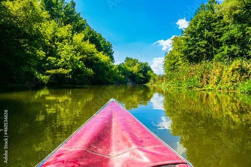 Kayaking down the river. River landscape with the bow of the boat in the foreground. Day time. Oskol river.