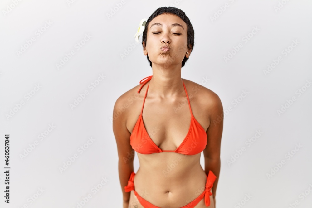 Young hispanic woman with short hair wearing bikini looking at the camera  blowing a kiss on air being lovely and sexy. love expression. Photos |  Adobe Stock