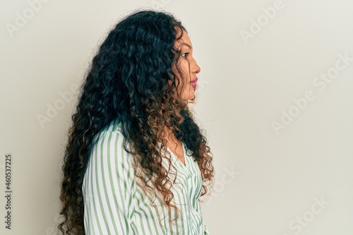 Young latin woman wearing casual clothes looking to side, relax profile pose with natural face with confident smile.