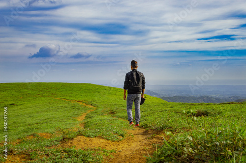 A backpacker walking on a hill with blue sky and copy space  man backpacking on a hill and blue sky background with copy space  successful man concept.