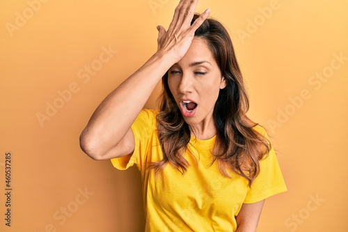 Young latin woman wearing casual clothes surprised with hand on head for mistake, remember error. forgot, bad memory concept.