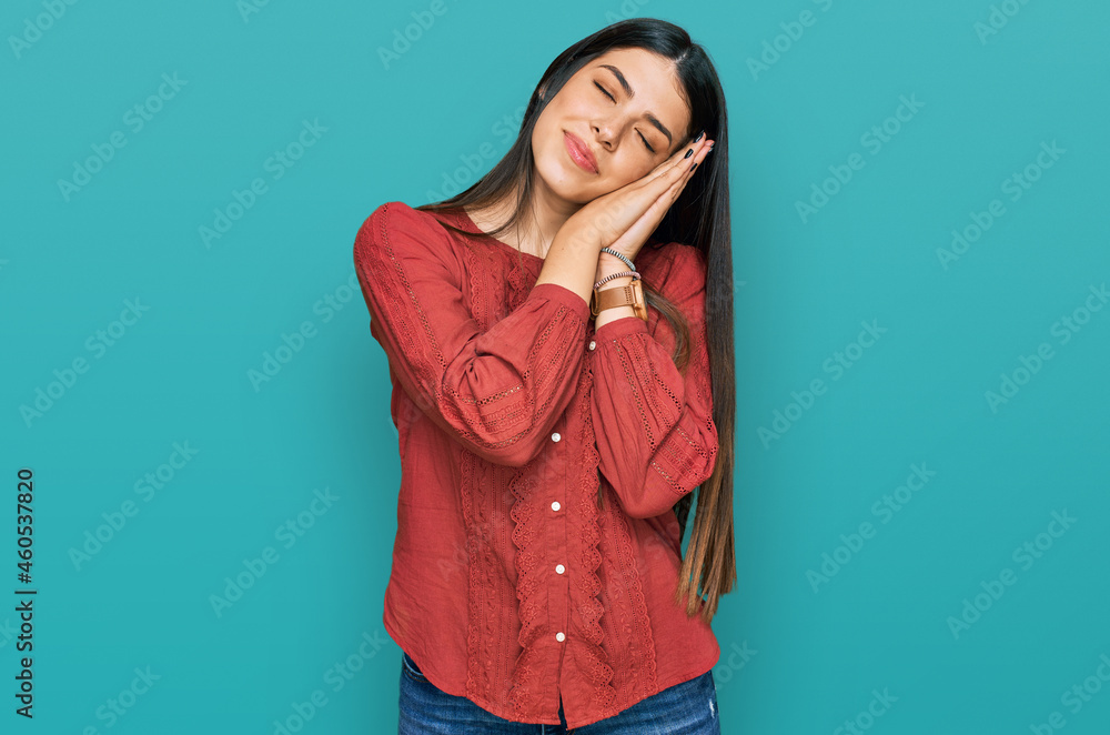 Young hispanic woman wearing casual clothes sleeping tired dreaming and posing with hands together while smiling with closed eyes. Young hispanic woman wearing casual clothes sleeping tired dreaming and posing with hands together while smiling with closed eyes.