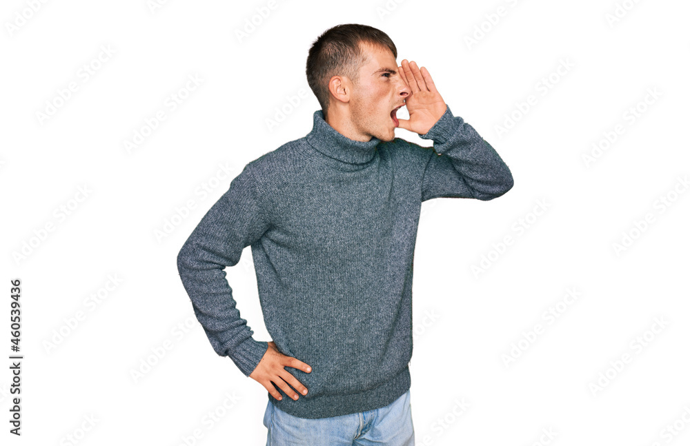 Young blond man wearing casual clothes shouting and screaming loud to side with hand on mouth. communication concept. Young blond man wearing casual clothes shouting and screaming loud to side with hand on mouth. communication concept.