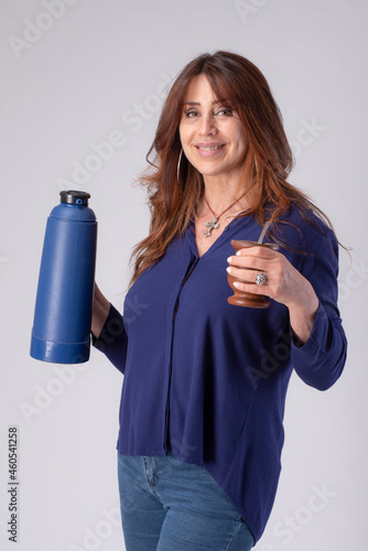 woman drinking mate, holding a termo