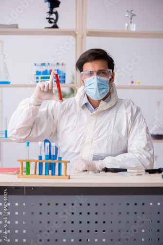 Young male chemist working at the lab during pandemic