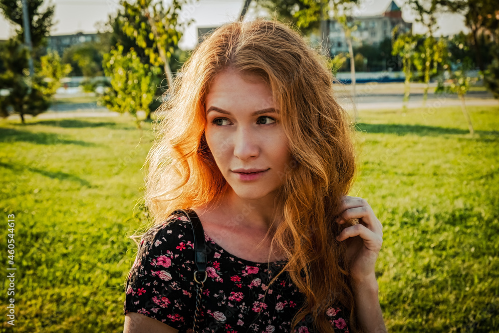 young redhead woman sitting on bench in park looking away the camera in calm state of mind young redhead woman sitting on bench in park looking away the camera in calm state of mind