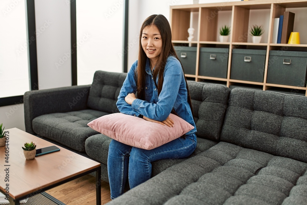 Young chinese girl smiling happy sitting on the sofa at home. Stock ...