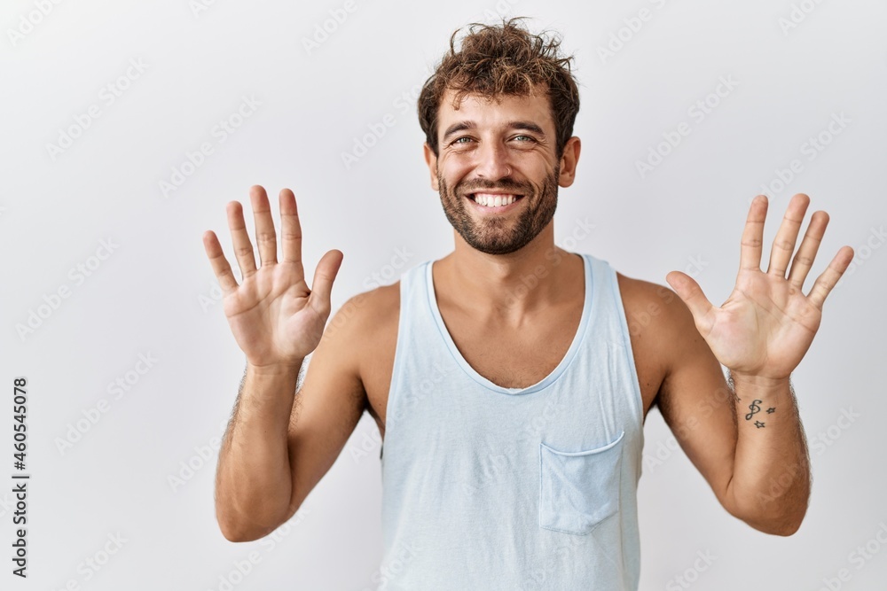 Young handsome man standing over isolated background showing and pointing up with fingers number ten while smiling confident and happy. Young handsome man standing over isolated background showing and pointing up with fingers number ten while smiling confident and happy.
