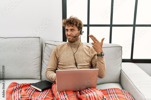 Foto Young handsome man with beard wearing operator headset working from home shooting and killing oneself pointing hand and fingers to head like gun, suicide gesture