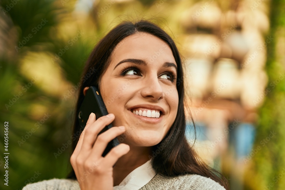 Young hispanic woman smiling happy talking on the smartphone at the city. Young hispanic woman smiling happy talking on the smartphone at the city.