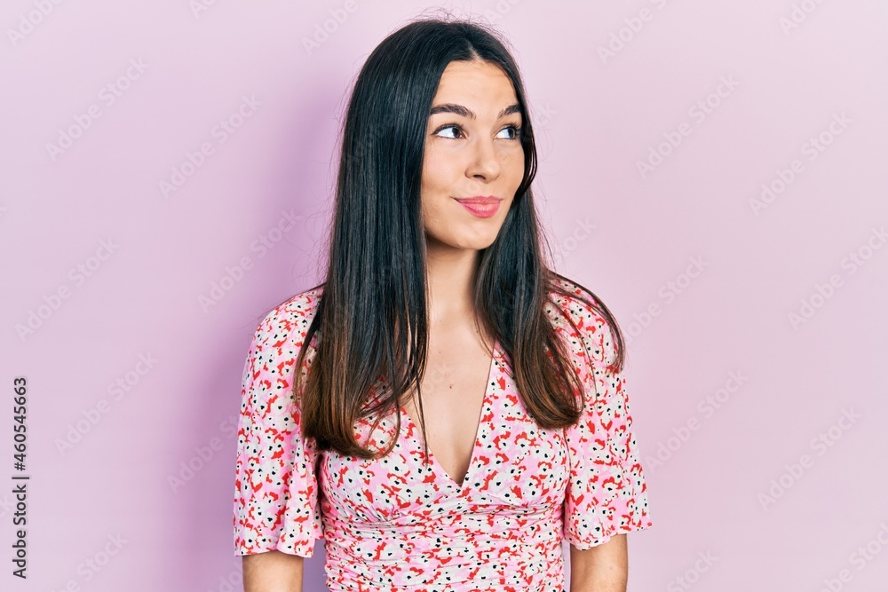 Young brunette woman wearing summer dress smiling looking to the side and staring away thinking. Young brunette woman wearing summer dress smiling looking to the side and staring away thinking.