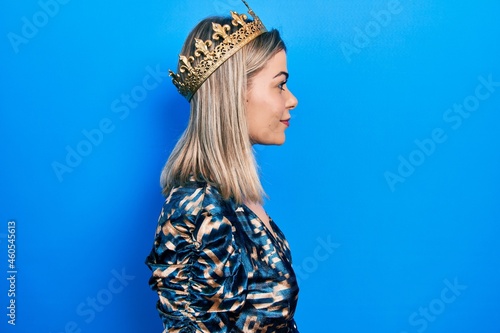 Beautiful caucasian woman wearing princess crown looking to side, relax profile pose with natural face with confident smile. photo